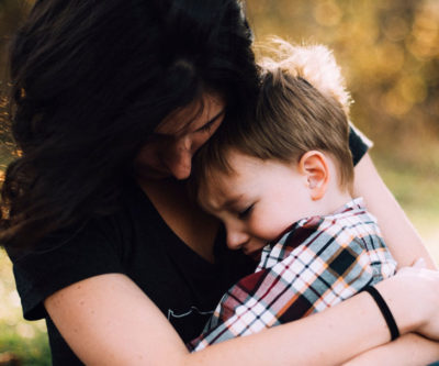 En kvinna som håller om ett ledset barn